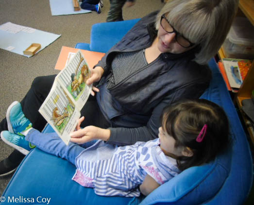 Teacher reading a picture book to a student