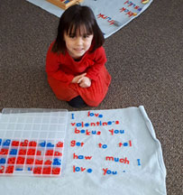 Little girl learning to spell with plastic letters