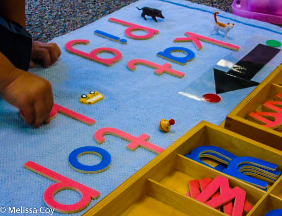 child spelling with wooden letters